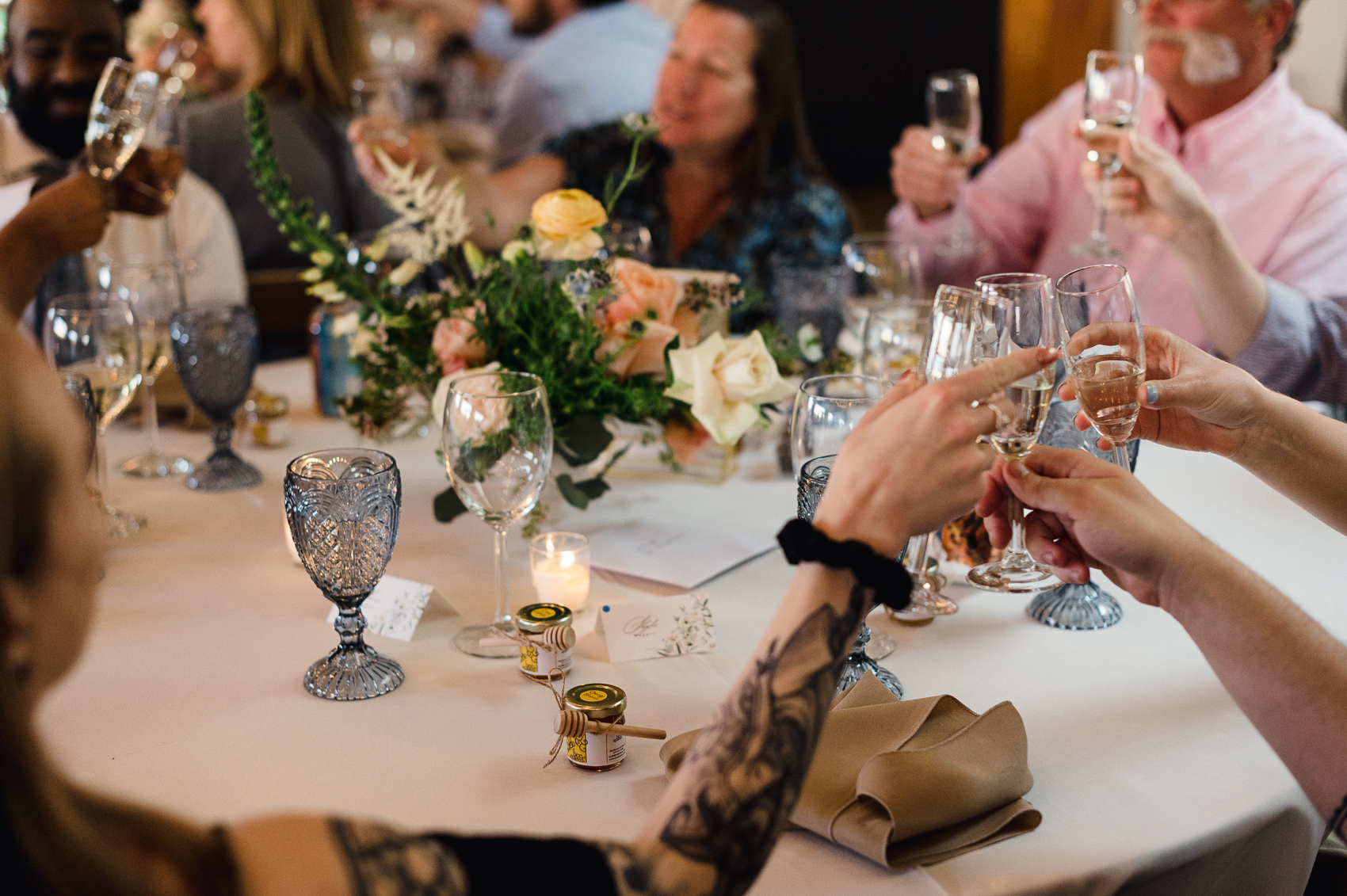 A group of family and friends laughing and toasting in celebration of the couple's boulder colorado wedding, radiating joy and love at the reception.