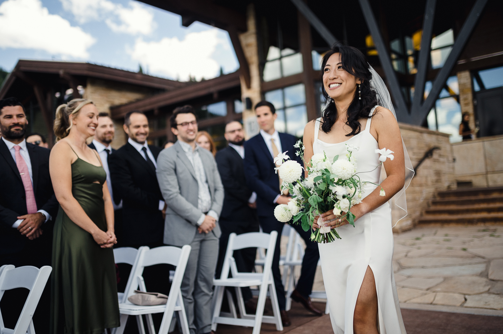 A stunning summer wedding ceremony at The 10th Vail, with the couple exchanging vows against a backdrop of breathtaking mountain views.